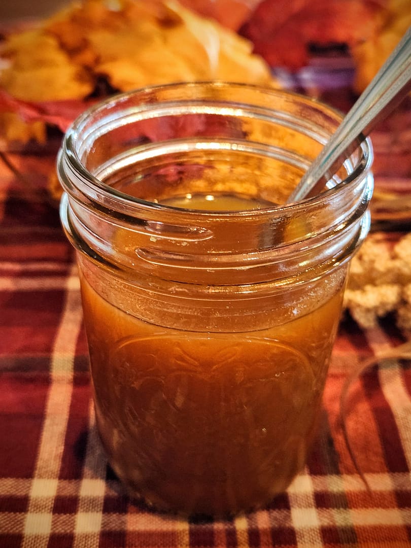 Mason jar of pumpkin spice syrup arranged on a fall display table