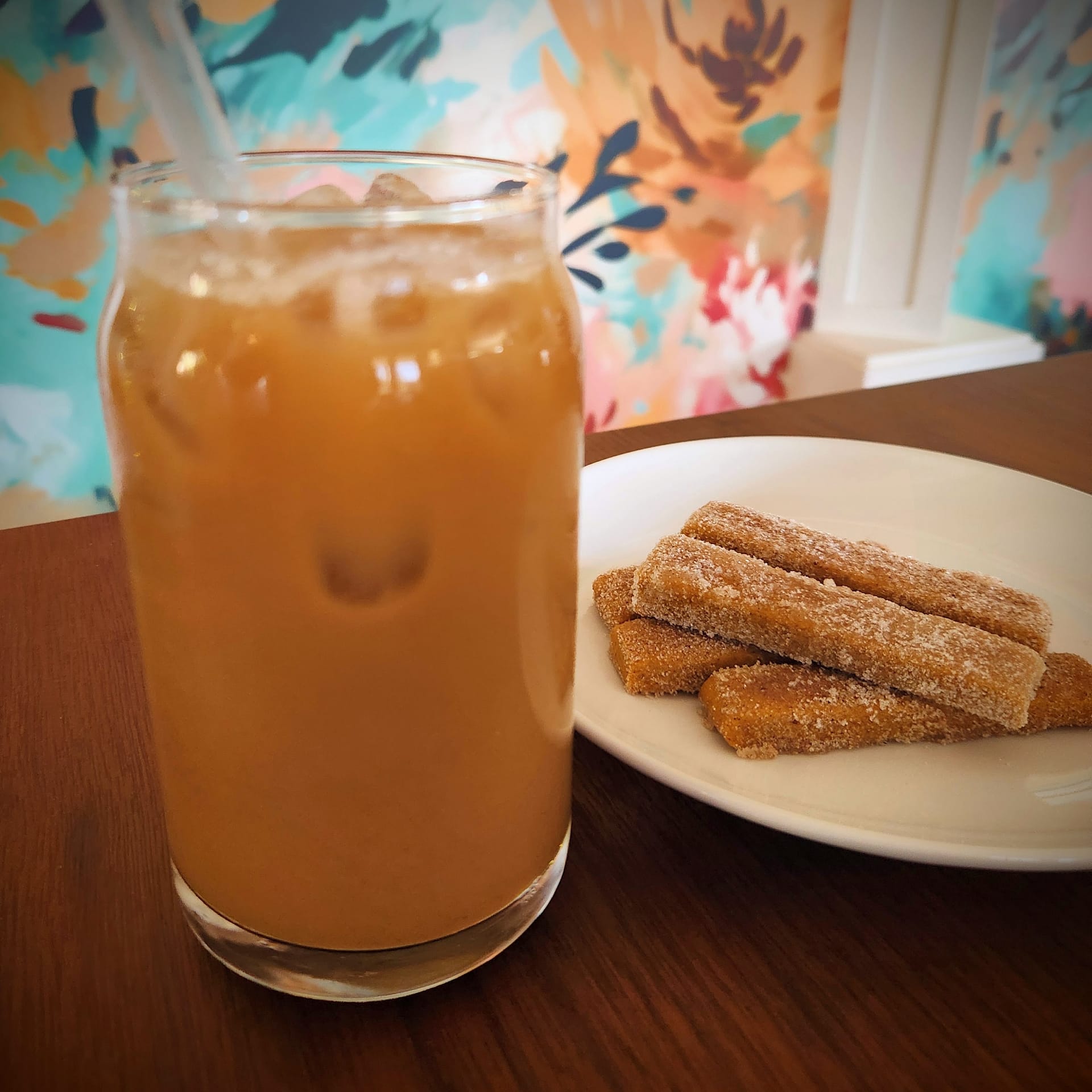 Cold-brew pumpkin spice latte with a plate of pumpkin stick cookies